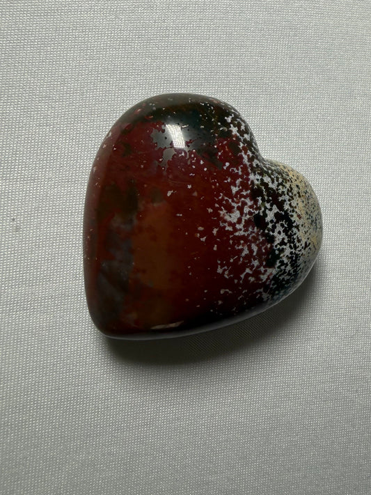 Heart-shaped brown stone on a light gray background