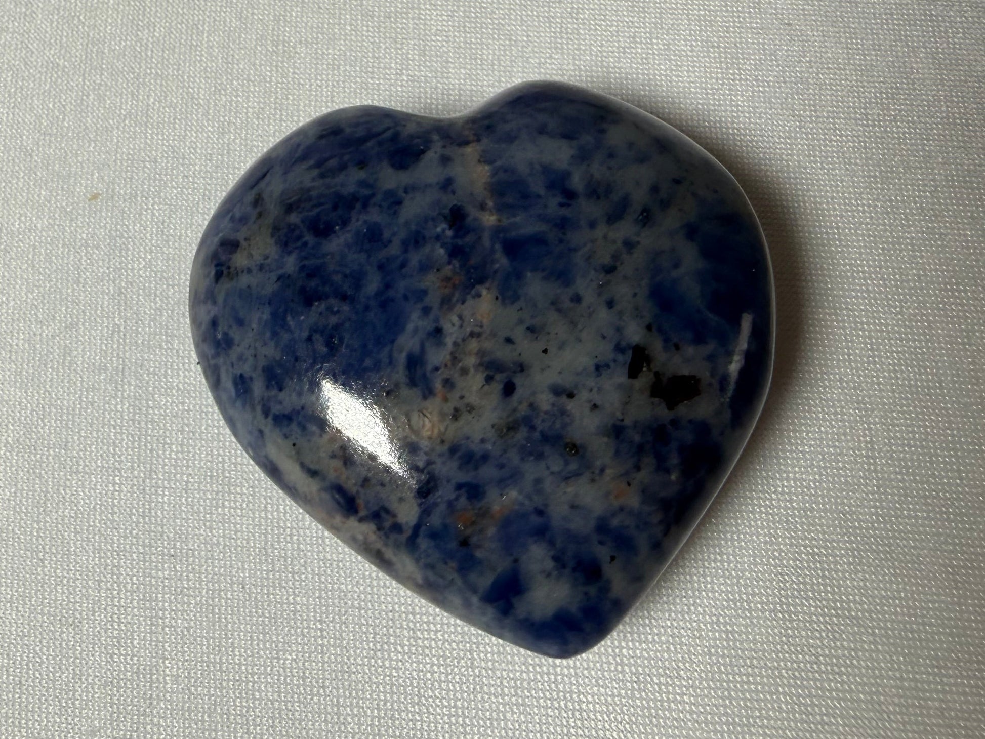 Heart-shaped blue stone on a light gray background