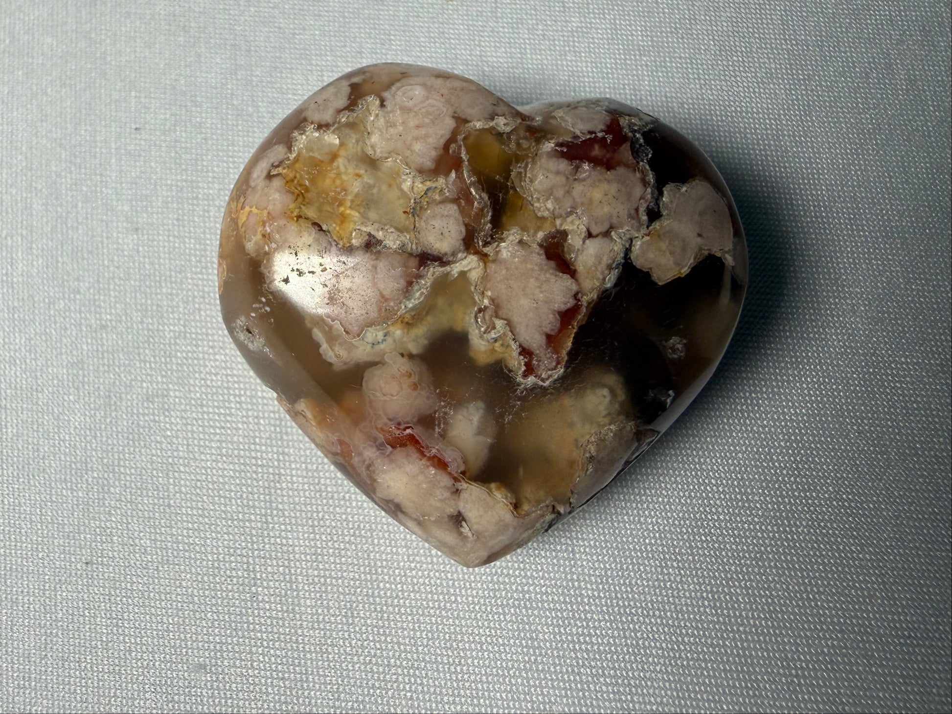 Heart-shaped stone on a light gray fabric background