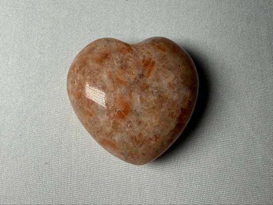 Heart-shaped stone on a gray fabric background
