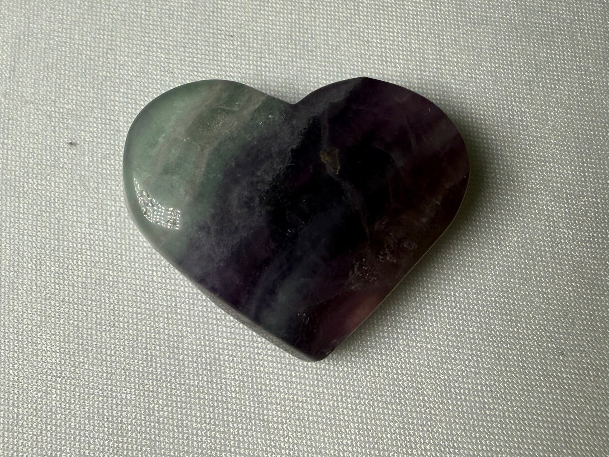 Heart-shaped stone on a textured beige surface