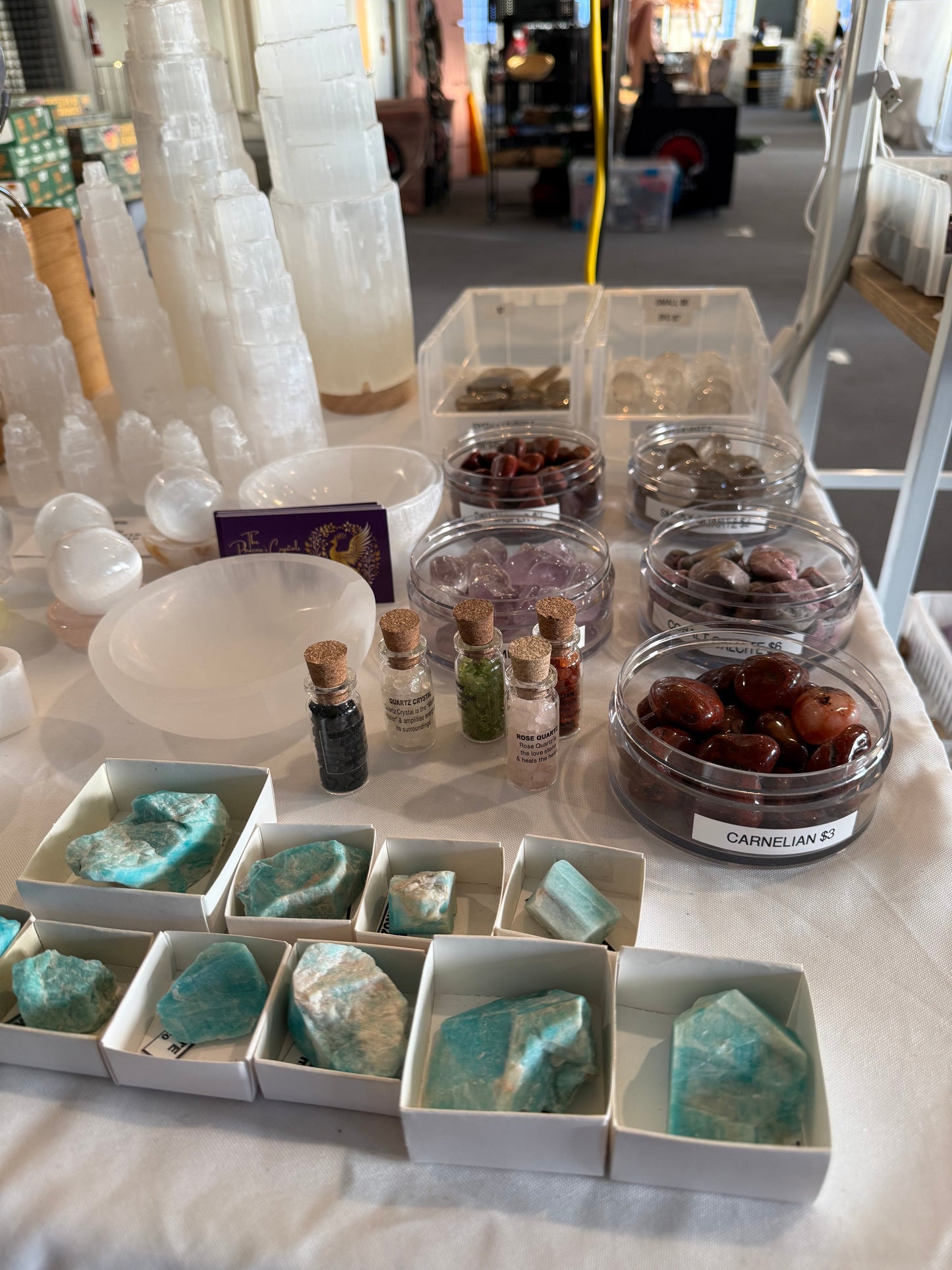 Mineral and crystal display with turquoise stones, small bottles, and other specimens on a table.